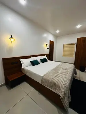 a bedroom with a large bed with white sheets and blue pillows at ThunderHill by Casablanca - A Premium Pool Villa in Meenangadi
