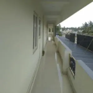 a hallway of a building with a dog sitting on it at Sai Home Stay in Marudhamalai