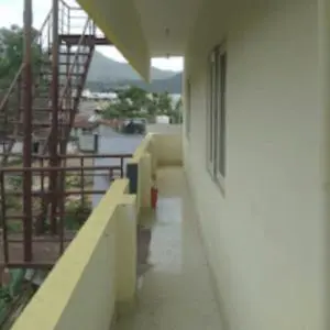 a hallway of a building with stairs and a balcony at Sai Home Stay in Marudhamalai