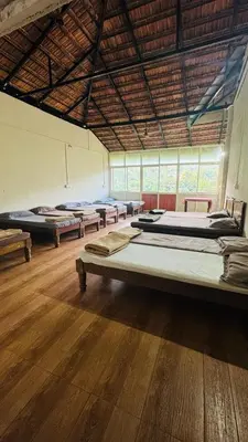 a large room with several beds in it at Hotel green land in Madikeri