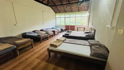 a room with a bunch of beds in it at Hotel green land in Madikeri