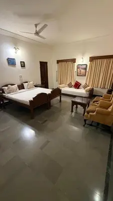 a large room with two beds and a couch at Hotel green land in Madikeri