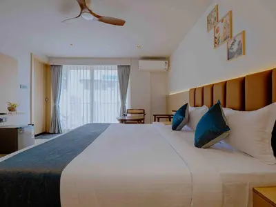 a bedroom with a large bed with blue pillows at Nine, Boutique hotel with luxury room stay, mysore in Mysore