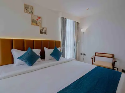 a bedroom with a large bed with blue pillows at Nine, Boutique hotel with luxury room stay, mysore in Mysore