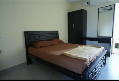 a bedroom with a large bed with a wooden headboard at Keerthana Marriage hall and Rooms in Coimbatore