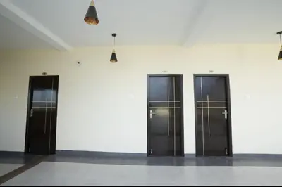 four elevators are lined up against a white wall at Keerthana Marriage hall and Rooms in Coimbatore