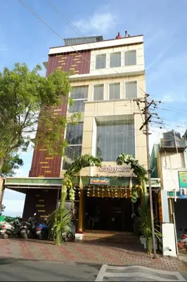 a building on a street with cars parked in front of it at Keerthana Marriage hall and Rooms in Coimbatore