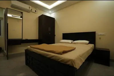 a bedroom with a large bed and a mirror at Keerthana Marriage hall and Rooms in Coimbatore