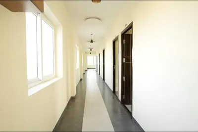 an empty corridor of a building with white walls and windows at Keerthana Marriage hall and Rooms in Coimbatore