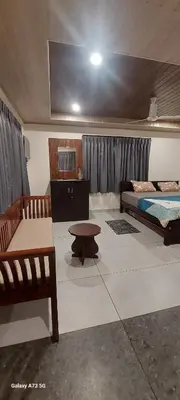 a room with a bed and a bench and a table at Hill valley farm resort in Viripara