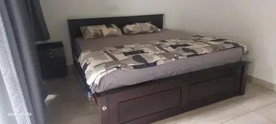 a bed in a bedroom with a wooden bed frame at Hill valley farm resort in Viripara