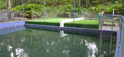 a tennis court in the middle of a pool of water at Hill valley farm resort in Viripara