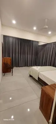 a bedroom with a bed and a window with curtains at Hill valley farm resort in Viripara