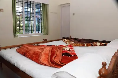 two beds sitting next to each other in a room at GEE VEE Home Stay in Munnar