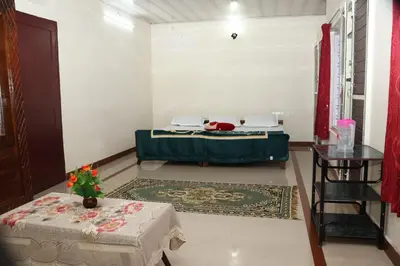 a room with a bed and a table in it at GEE VEE Home Stay in Munnar