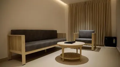 a living room with a couch and a chair at Vanaalayam Retreat Palladam By Arcadia in Palladam