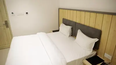 a large bed with white sheets and pillows at Vanaalayam Retreat Palladam By Arcadia in Palladam