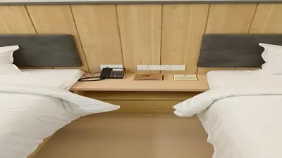 a bedroom with two beds and a phone on a table at Vanaalayam Retreat Palladam By Arcadia in Palladam