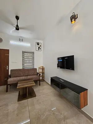 a living room with a couch and a flat screen tv at Dream nest beach house Resort with private beach entrance in Trichūr