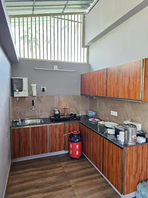 a large kitchen with wooden cabinets and a red appliance at Dream nest beach house Resort with private beach entrance in Trichūr