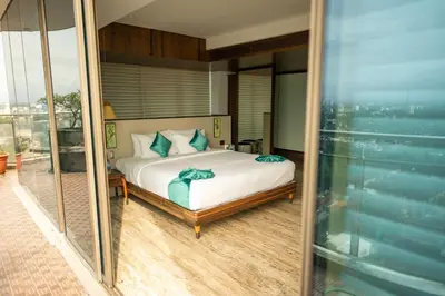 a bedroom with a bed with blue pillows at MARINE DRIVE - BEACH FRONT LUXURY PENTHOUSE by NIOTEL in Kozhikode