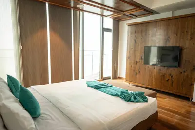 a bedroom with a bed with a television on a wall at MARINE DRIVE - BEACH FRONT LUXURY PENTHOUSE by NIOTEL in Kozhikode