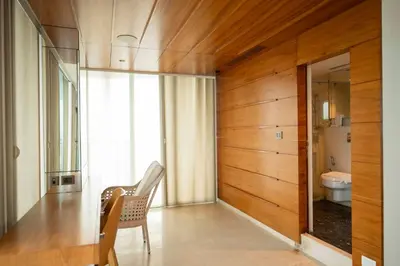 a bathroom with a chair and a toilet in a room at MARINE DRIVE - BEACH FRONT LUXURY PENTHOUSE by NIOTEL in Kozhikode