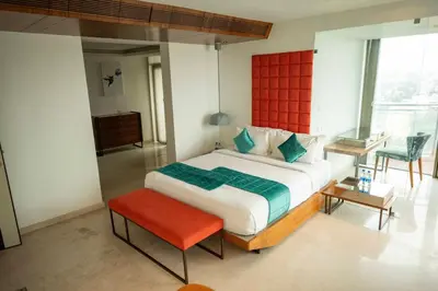 a bedroom with a large bed with a red headboard at MARINE DRIVE - BEACH FRONT LUXURY PENTHOUSE by NIOTEL in Kozhikode