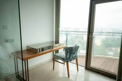 a desk and a chair in a room with a window at MARINE DRIVE - BEACH FRONT LUXURY PENTHOUSE by NIOTEL in Kozhikode