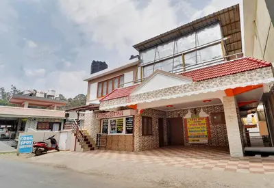 a building with a motorcycle parked in front of it at Coolspot Cottage in Ooty