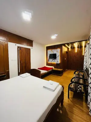 a bedroom with a large bed and a tv at Coolspot Cottage in Ooty
