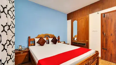 a bedroom with a bed with a red and white blanket at Coolspot Cottage in Ooty