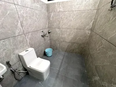 a bathroom with a toilet and a sink at Gcc Saffron in Wayanad