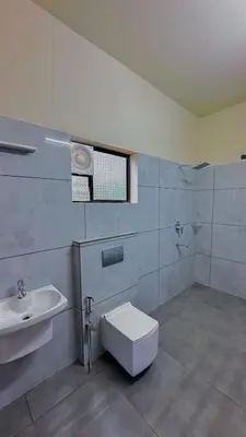 a bathroom with a toilet and a sink at Gcc Saffron in Wayanad