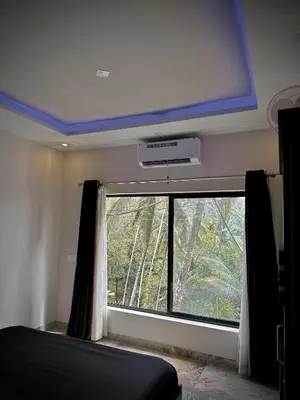a room with a large window with avertisement at Gcc Saffron in Wayanad