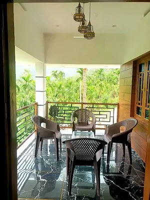 a patio with chairs and a table on a balcony at Wildlife Homestay in Kanthalloor