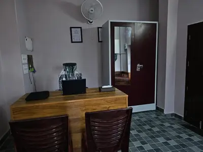 a wooden counter with two chairs and a mirror at Guruvayur Nest Homestay in Guruvāyūr