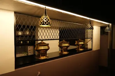 a shelf with three vases and lights on it at Guruvayur Nest Homestay in Guruvāyūr