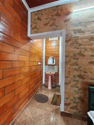 a bathroom with a brick wall with a sink at Nasmat Resort in Masinagudi
