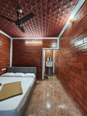 a room with a bed and a brick wall at Nasmat Resort in Masinagudi