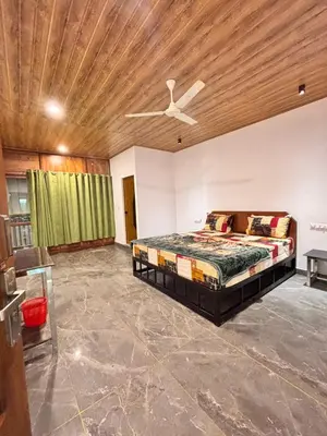 a bedroom with a bed and a ceiling fan at Soul Stay in Munnar