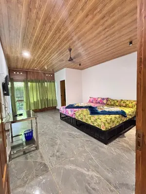 a bedroom with two beds and a wooden ceiling at Soul Stay in Munnar