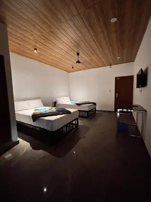 a bedroom with two beds and a wooden ceiling at Soul Stay in Munnar