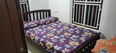 a bed with a purple comforter with flowers on it at Periyar Heritage in Kotamangalam
