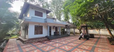 a house with a scooter parked in front of it at Periyar Heritage in Kotamangalam