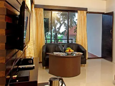 a living room with two chairs and a table at Coorg Heights in Madikeri