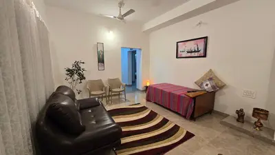 a living room with a couch and a bed at The Horalahalli House in Mysore