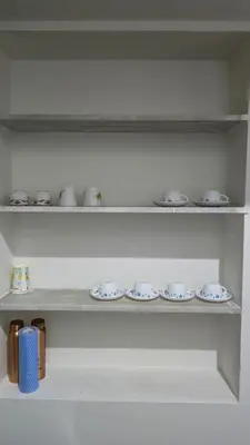 a shelf with plates and cups on it at The Horalahalli House in Mysore