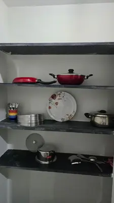 a shelf with plates and bowls and pans on it at The Horalahalli House in Mysore