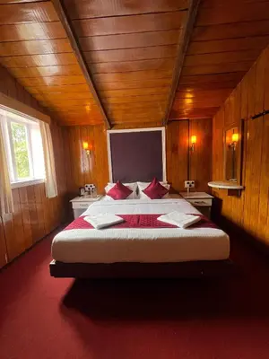 a bedroom with a large bed in a wooden room at The Groot in Ooty
